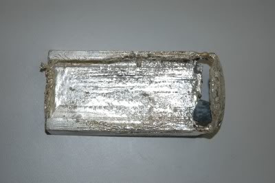 A hollowed-out 100 ounce (oz) Engelhard silver bar, that had been partially melted when it the lead insides were discovered, view from the bottom.